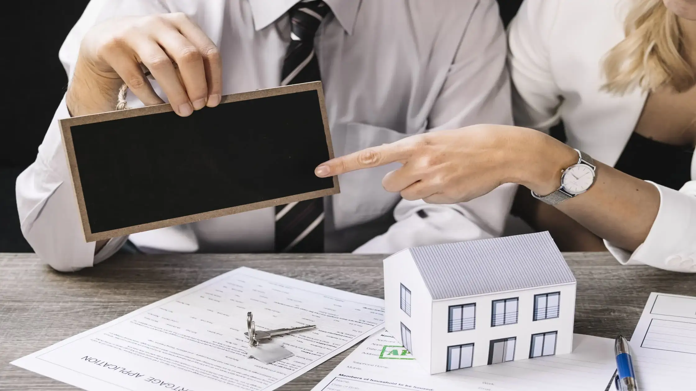 landlord-holding-sign-over-rental-application-scam-red-flags