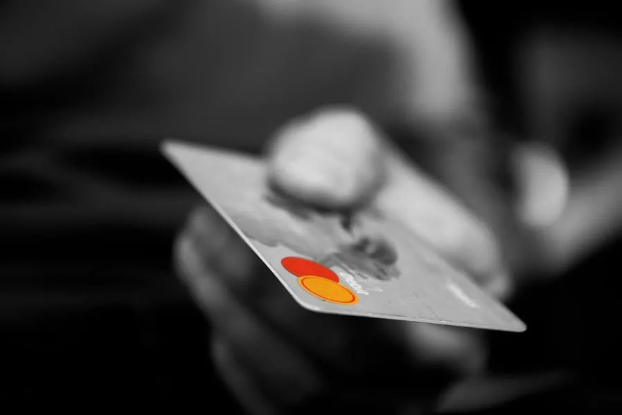 Hand holding a credit card while reviewing apartment rental options with bad credit.