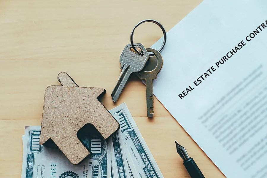 house-keys-cash-and-a-real-estate-contract-on-a-desk-showing-how-tenant-screening-laws-by-state-cap-fees