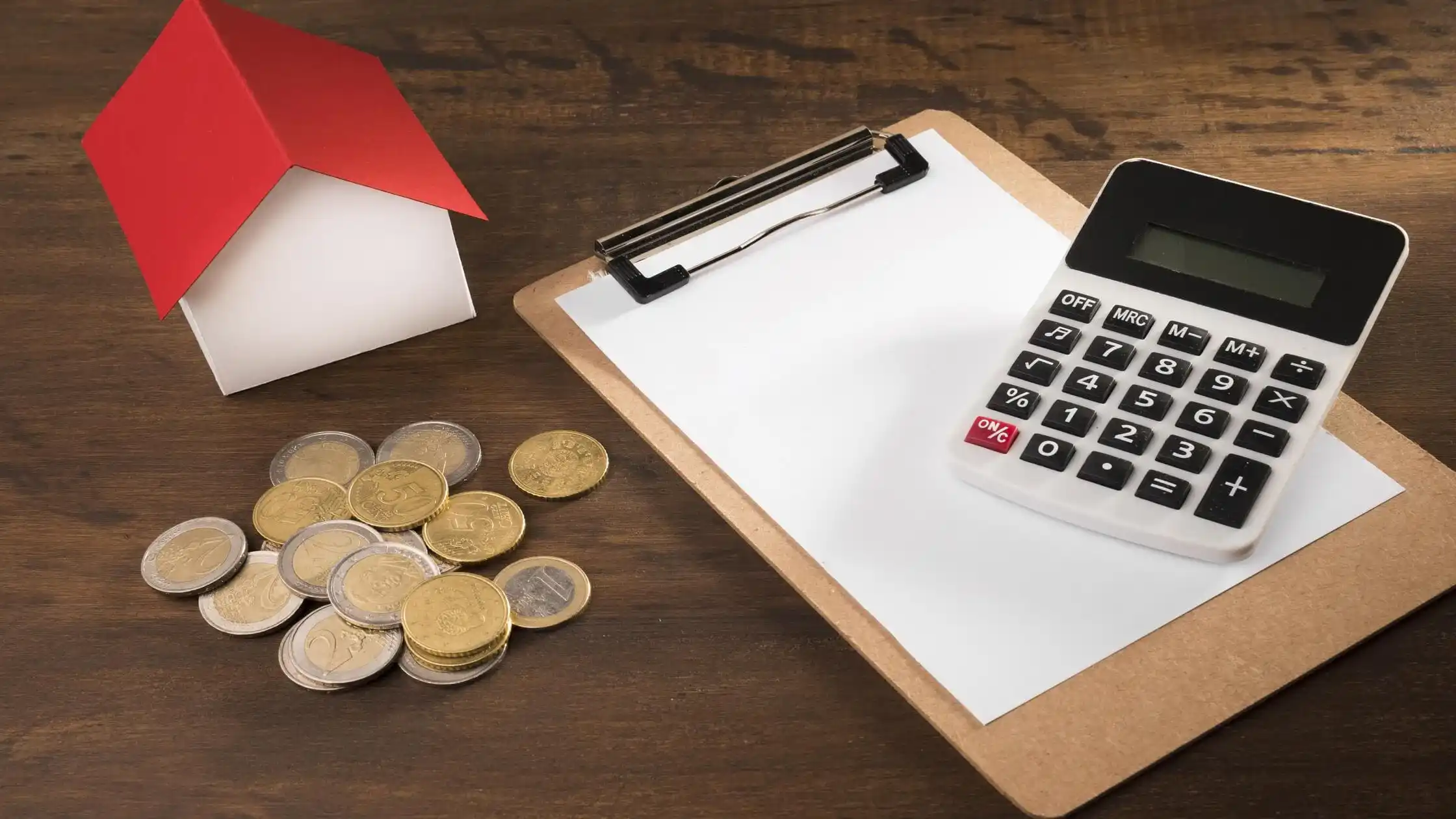 calculator-and-blank-clipboard-next-to-a-paper-house-and-coins-comparing-options-to-break-a-lease-for-less