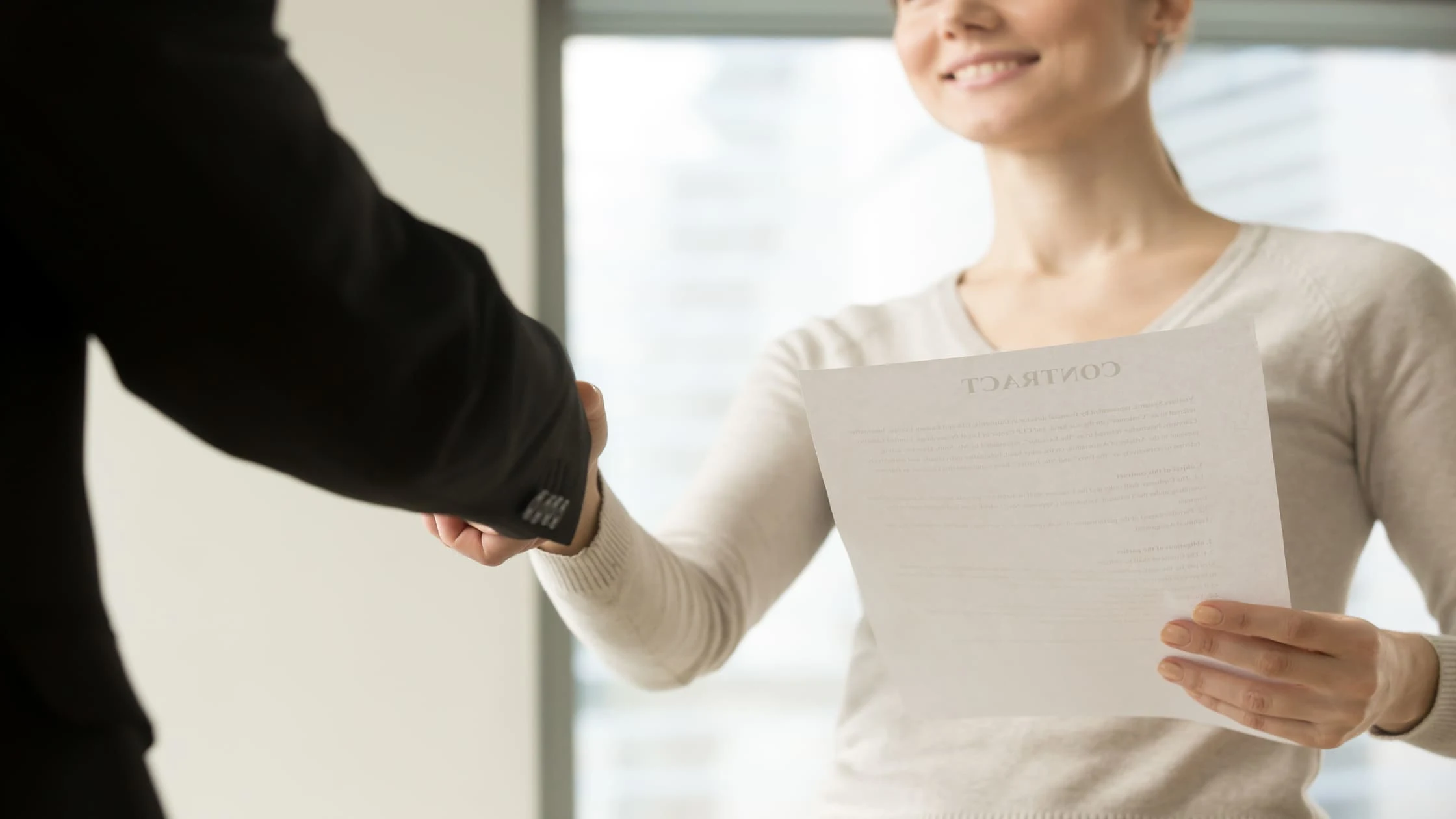 Landlord and new tenant shaking hands over a contract, avoiding common welcome letter mistakes.