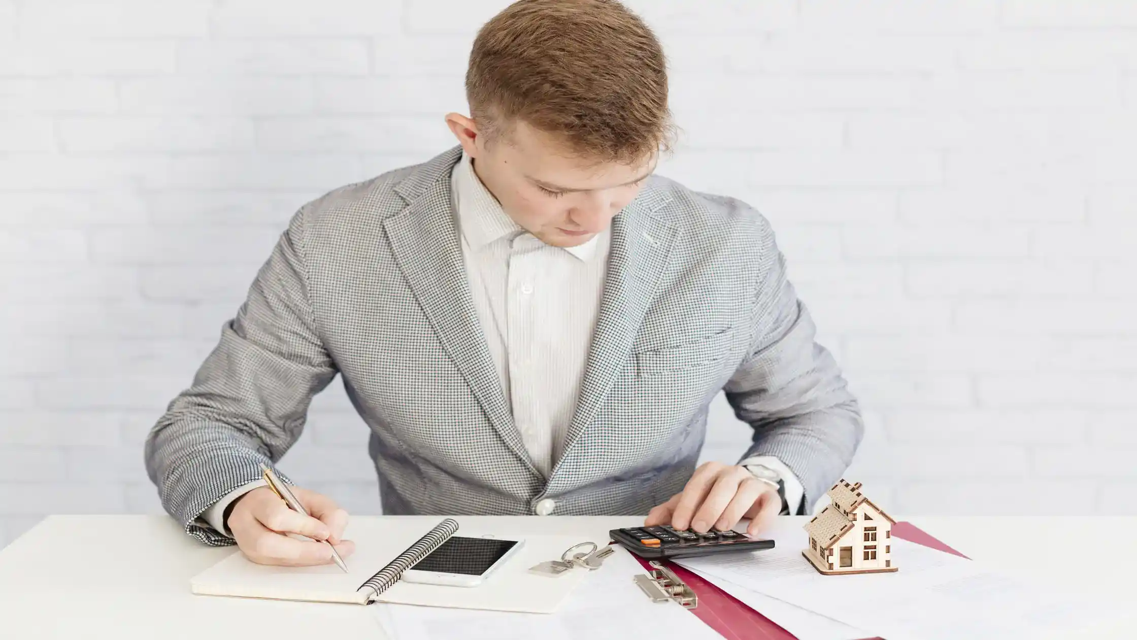 agent-at-a-desk-with-a-calculator-keys-and-a-model-house-adding-up-the-hidden-costs-of-breaking-a-lease