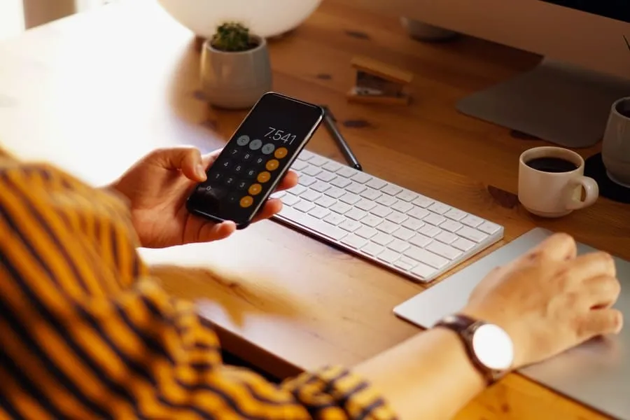 Home office desk with a phone calculator, showing the rent affordability math behind an RS3 score.