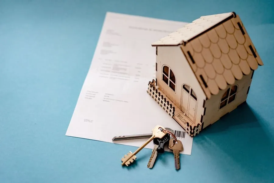 House model and keys on a rental listing contract.