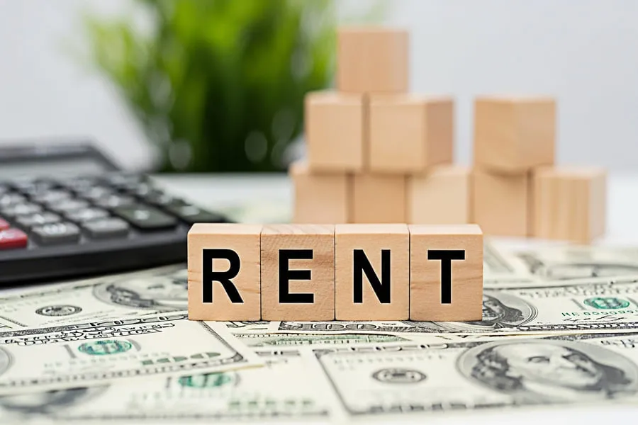 Rent wood blocks on dollar bills representing free rental history report and payment costs.