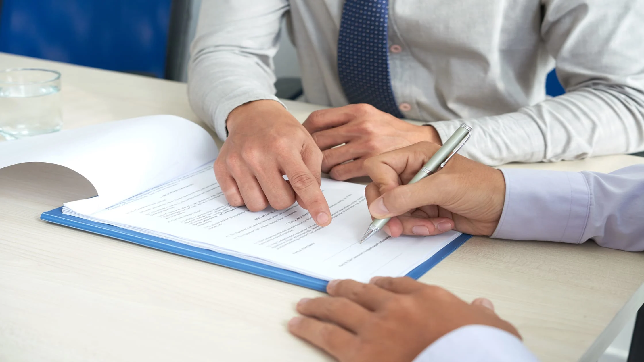 landlord-and-tenant-reviewing-and-signing-lease-agreement-document-at-desk