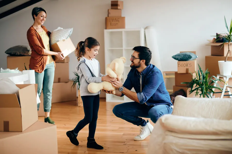 Family unpacking boxes and settling in after renting an apartment for the first time.