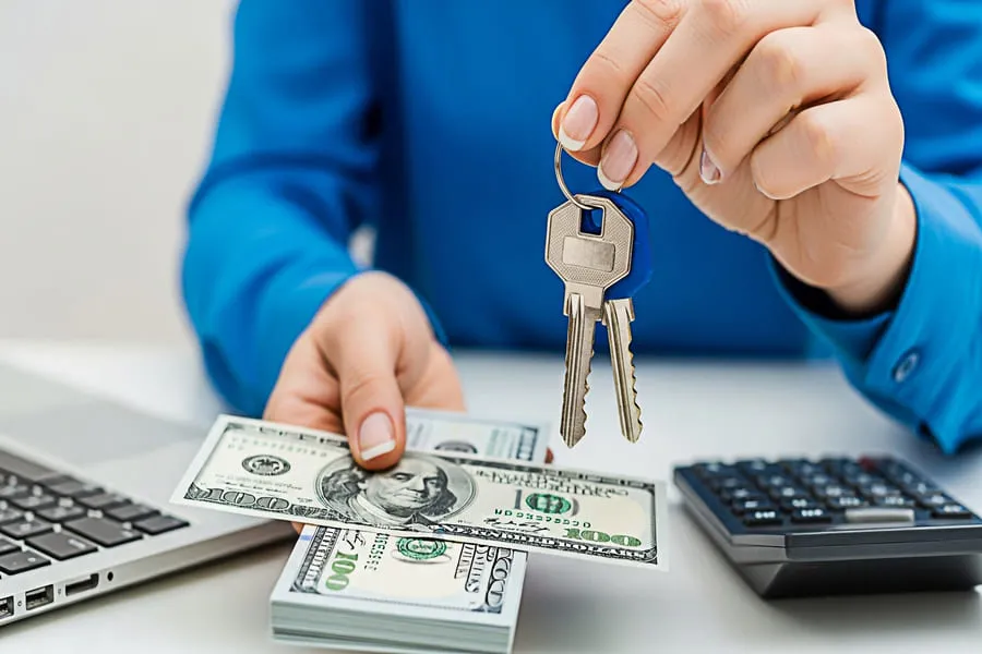 Leasing agent holding apartment keys and deposit payment during move-in after rental application is approved.