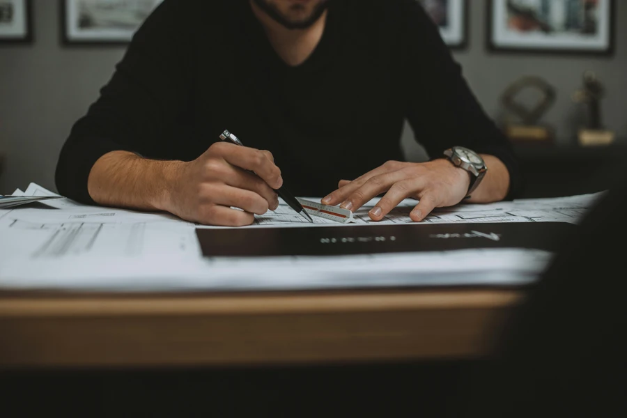 Professional reviewing property blueprints to evaluate ROI and how much are realtor fees for rentals.