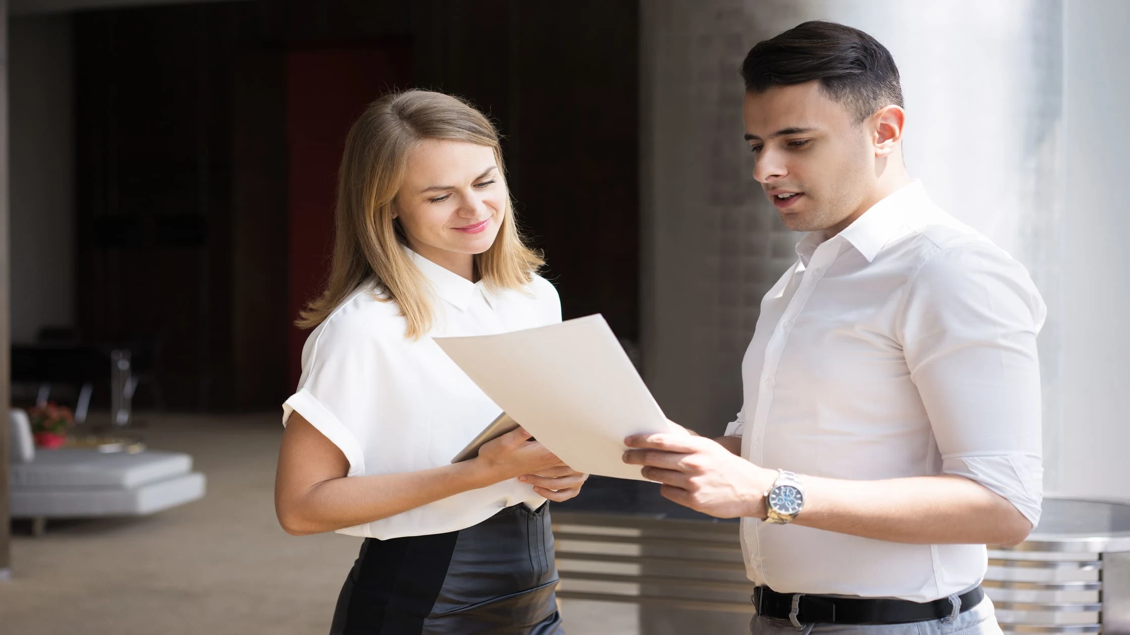 Landlord walking a new tenant through a printed checklist for a tenant welcome letter.