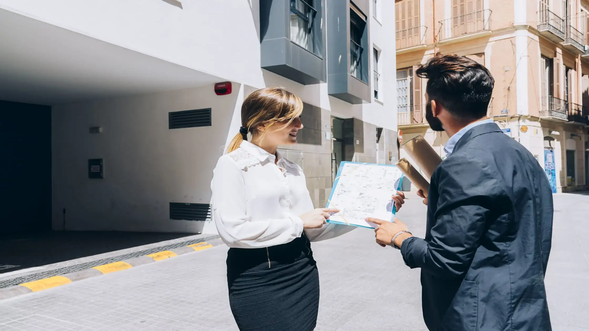 Leasing agent showing a tenant a property map, discussing how to protect their credit when applying