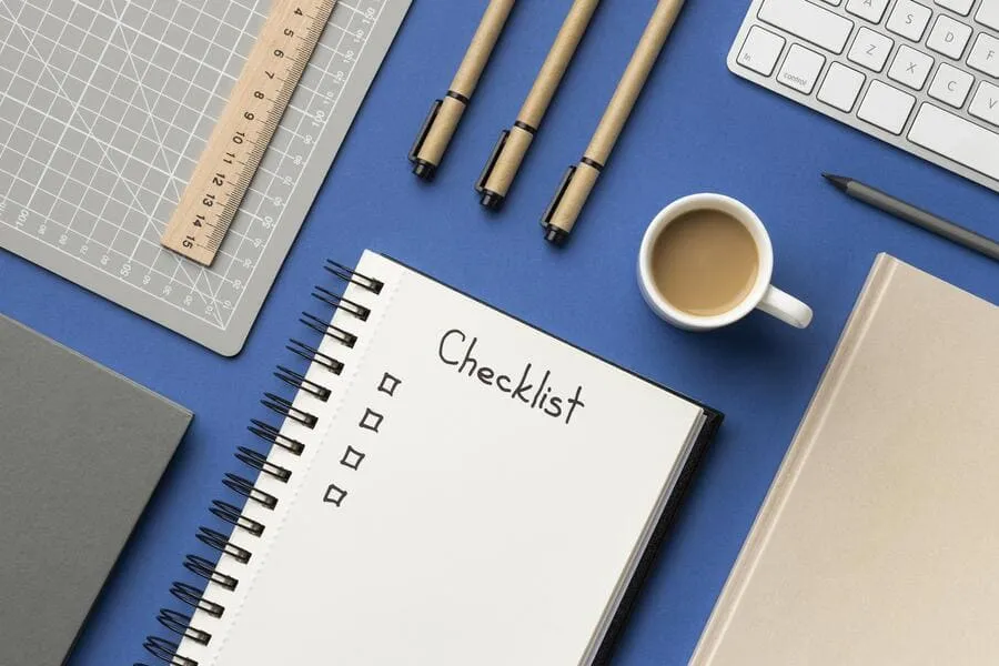 Notebook labeled Checklist with empty boxes and pens for a printable turnover checklist